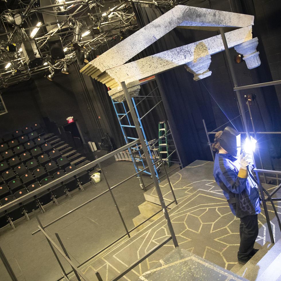 A theatre student welds a piece of metal during construction of a set.