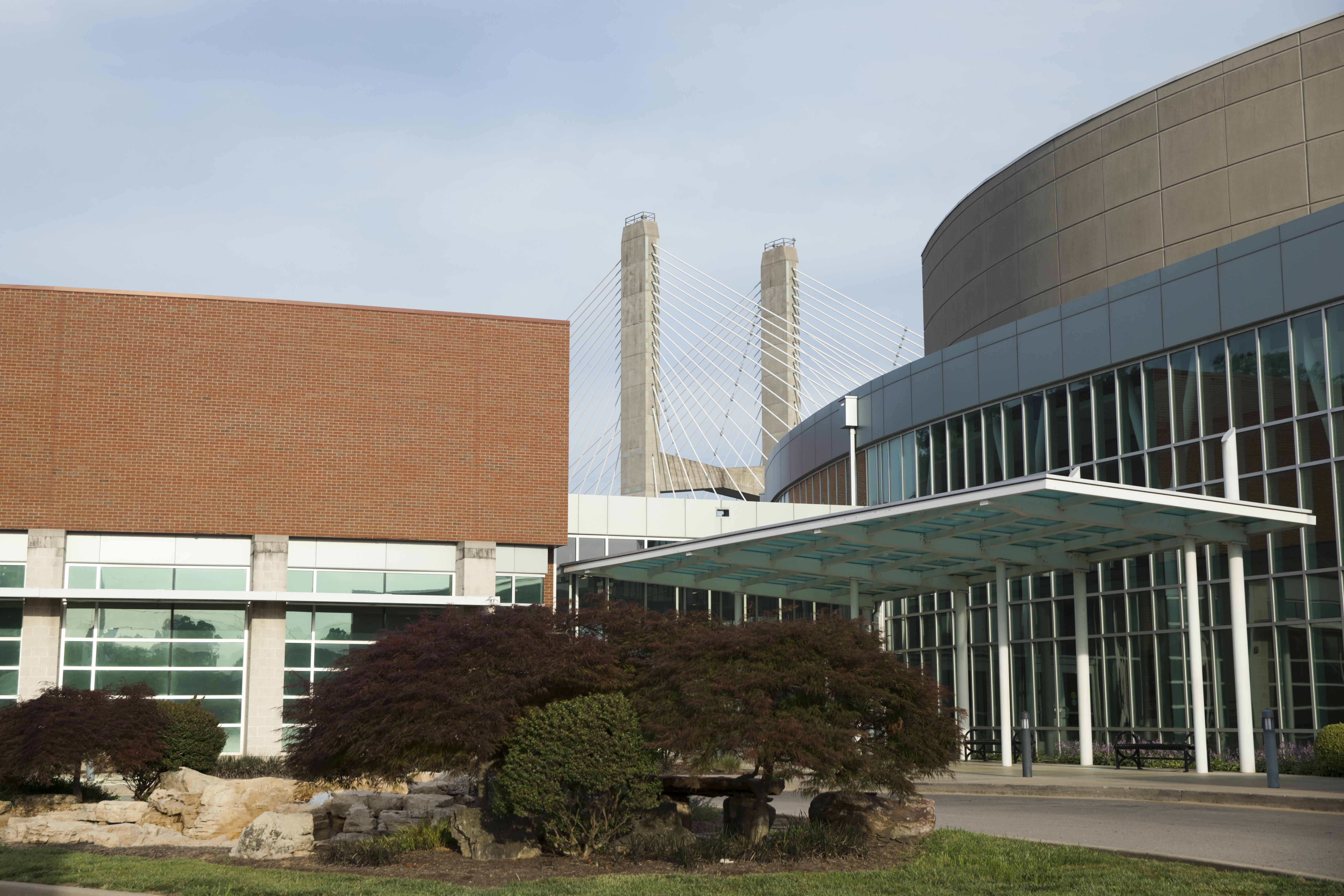 view of the river campus cultural arts center from the parking lot. the supports of the Mississippi River bridge behind the building