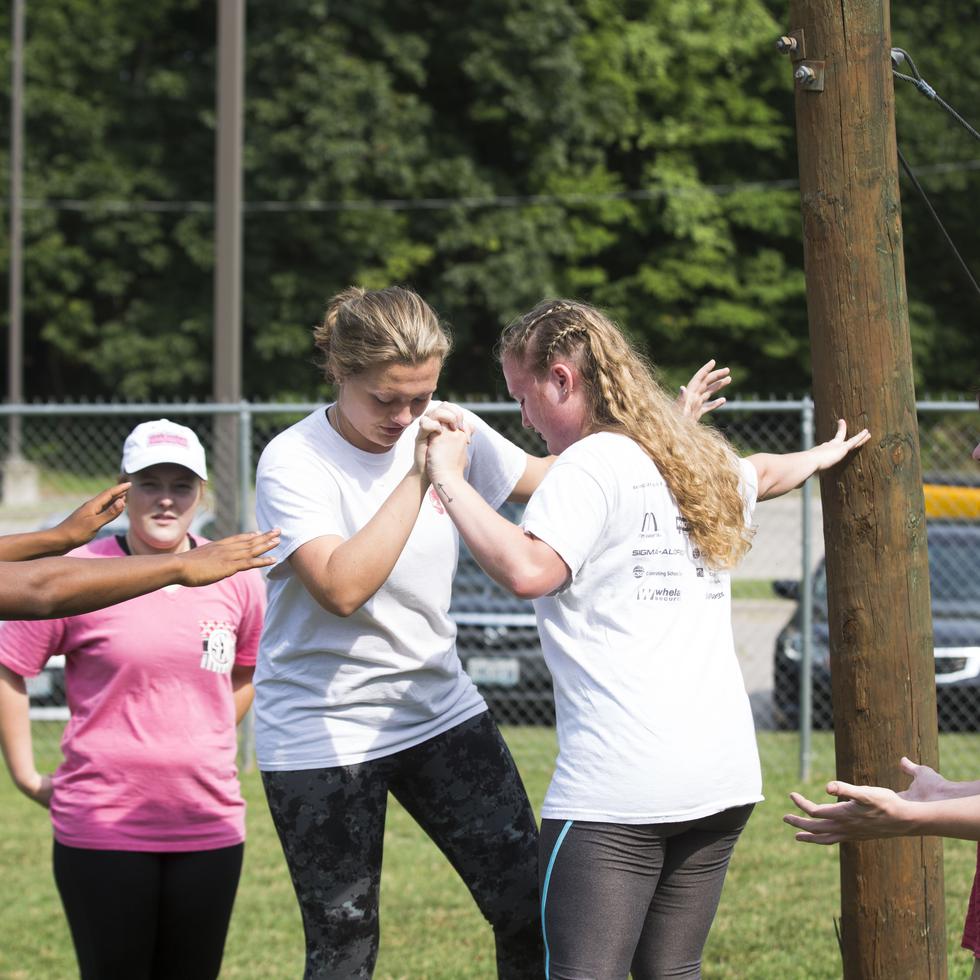 students help each other while they complete the challenge course